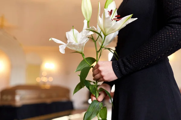 Close up van vrouw met lelie bloemen bij begrafenis — Stockfoto