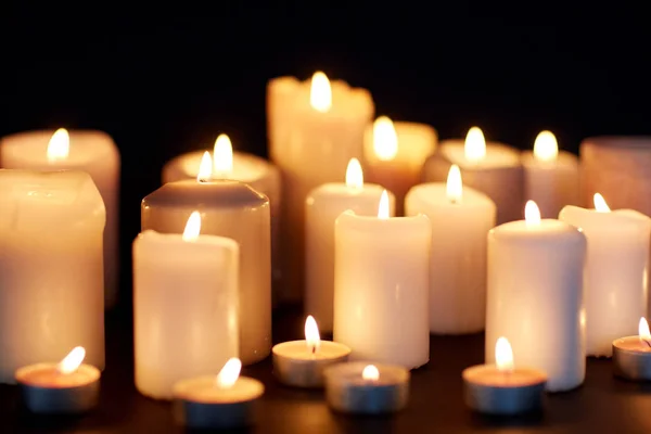 Candele che bruciano nel buio su sfondo nero — Foto Stock