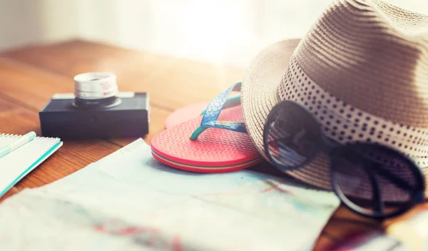 Plan rapproché de la carte de voyage, des tongs, du chapeau et de la caméra — Photo