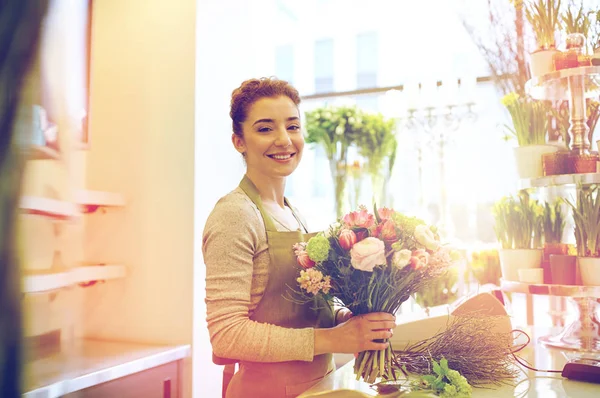Lächelnde Floristin macht Strauß im Blumenladen — Stockfoto