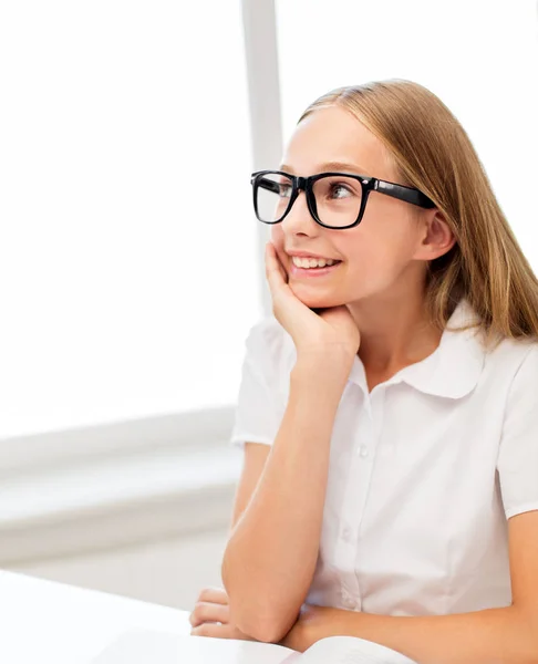 Glückliche Schülerin mit Brille und Buch in der Schule — Stockfoto