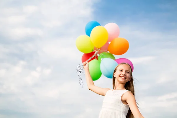 Menina feliz em óculos de sol com balões de ar — Fotografia de Stock