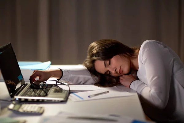 Zmęczony kobiecie spania na office tabela w nocy — Zdjęcie stockowe