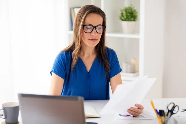 Happy woman with papers and laptop at office — Stock Photo, Image