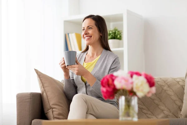 Glückliche Frau trinkt Tee oder Kaffee zu Hause — Stockfoto