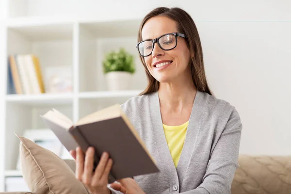 Jeune femme dans des lunettes livre de lecture à la maison — Photo