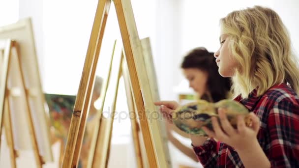 Estudiantes con caballetes pintando en la escuela de arte — Vídeo de stock