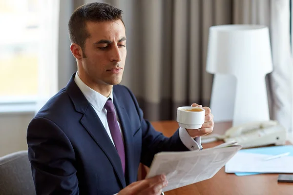 Empresario leyendo periódico y tomando café — Foto de Stock