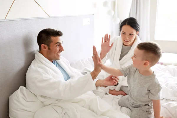 Famiglia felice a letto a casa o in camera d'albergo — Foto Stock