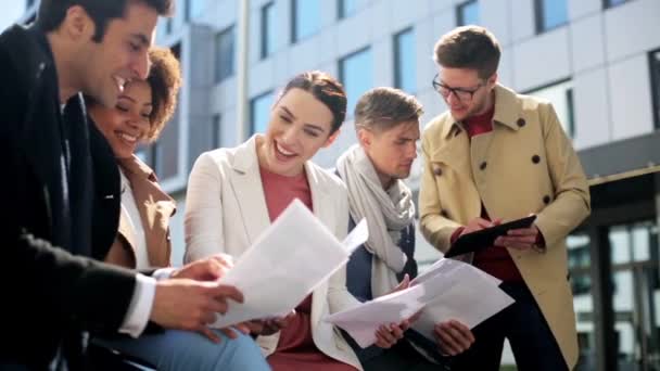 Equipe de negócios internacional com papéis ao ar livre — Vídeo de Stock