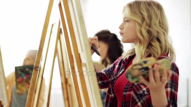 Students with easels painting at art school — Stock Video