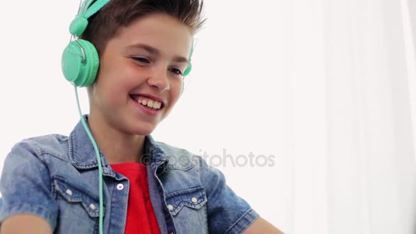 Lycklig pojke i hörlurar skrattar hemma — Stockvideo