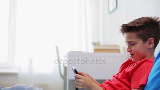 Niño sonriente con tablet PC en casa — Vídeo de stock