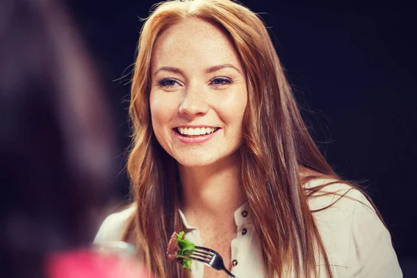 Happy young woman having dinner at restaurant — Stock Photo, Image