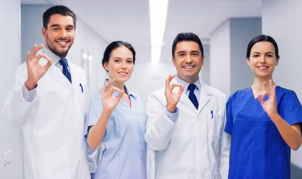 Groupe de médecins à l'hôpital montrant ok signe de main — Photo