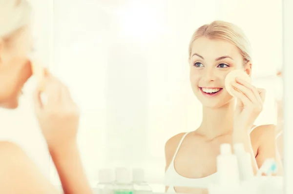 Young woman washing face with sponge at bathroom — Stock Photo, Image