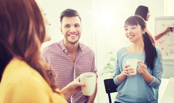 Lykkelig kreativt team som drikker kaffe på kontoret – stockfoto