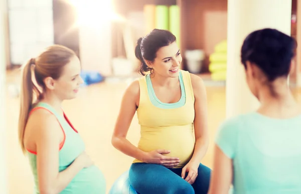 Mulheres grávidas felizes sentadas em bolas no ginásio — Fotografia de Stock