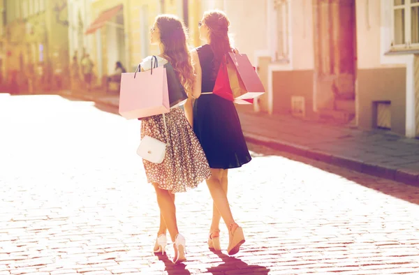 Glada kvinnor med påsar promenader i city — Stockfoto