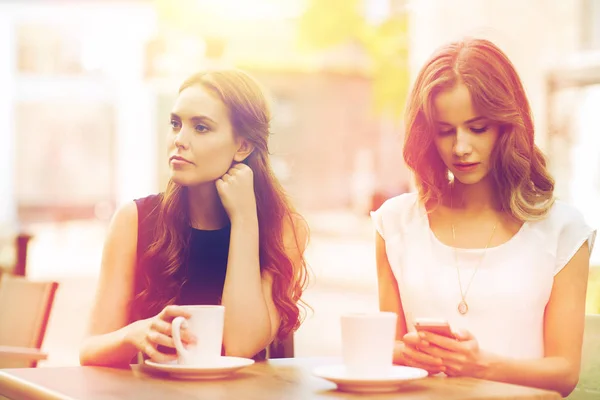 Mujeres con teléfonos inteligentes y café en la cafetería al aire libre — Foto de Stock