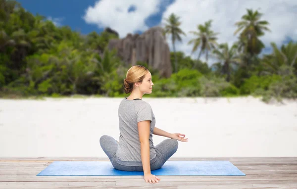 Frau macht Yoga in Twist-Pose am Strand — Stockfoto