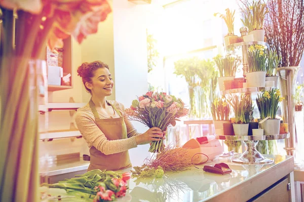 Sonriente florista mujer haciendo ramo en floristería — Foto de Stock