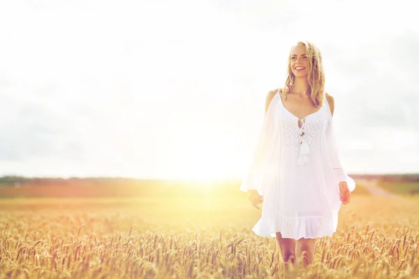 Sorrindo jovem mulher em vestido branco no campo de cereais — Fotografia de Stock