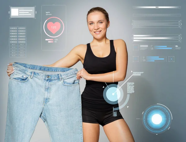 Joven delgada mujer deportiva mostrando pantalones de gran tamaño — Foto de Stock