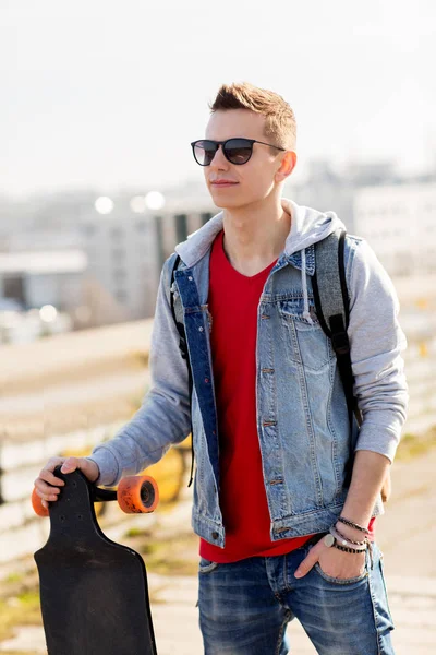 Happy young man or teenage boy with longboard — Stock Photo, Image