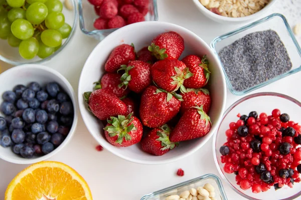 Frutas y bayas en cuencos en la mesa — Foto de Stock