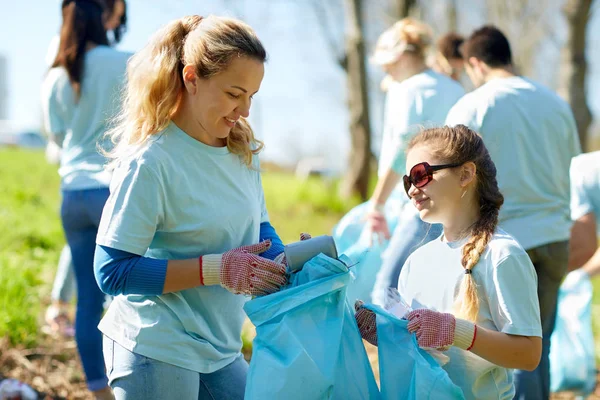 Voluntarios con bolsas de basura limpieza área del parque —  Fotos de Stock