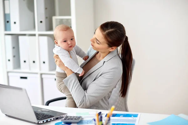 Ευτυχής επιχειρηματίας με το μωρό και φορητό υπολογιστή στο γραφείο — Φωτογραφία Αρχείου