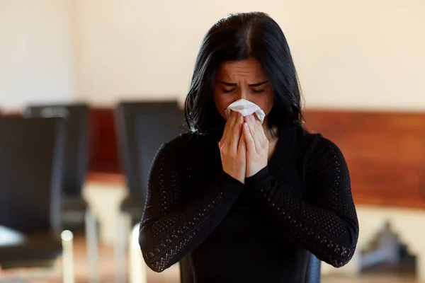 Плачущая женщина с салфеткой на похоронах в церкви — стоковое фото