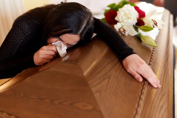 Woman with coffin crying at funeral in church — Stock Photo, Image