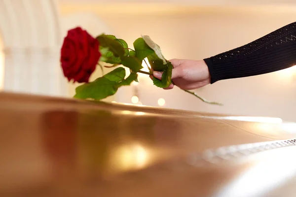 Mulher com rosas vermelhas e caixão no funeral — Fotografia de Stock