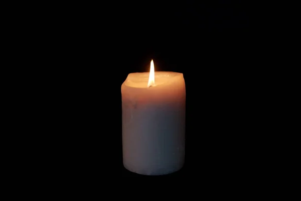 Свічка горить у темряві над чорним тлом — стокове фото