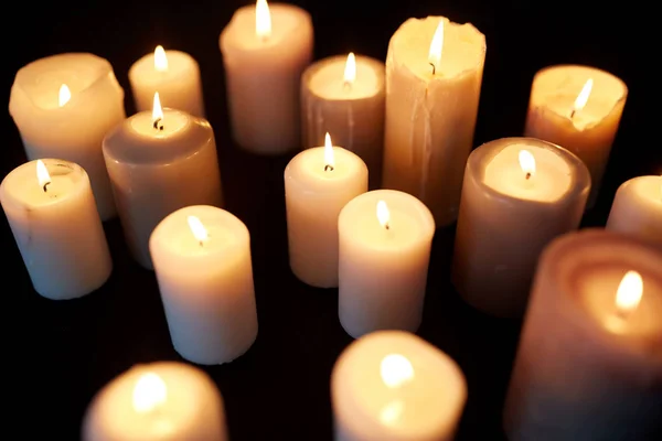 Candles burning in darkness over black background — Stock Photo, Image