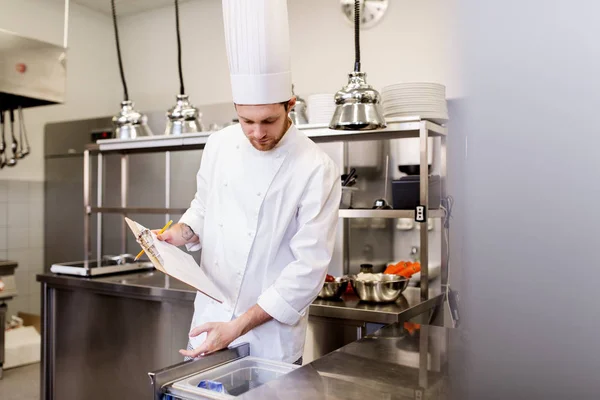 Chef with clipboard doing inventory at kitchen — Stock Photo, Image