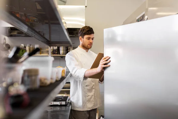 Chef con portapapeles haciendo inventario en la cocina —  Fotos de Stock