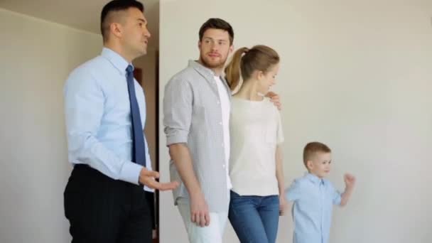 Счастливая семья и риэлтор в новом доме или квартире — стоковое видео
