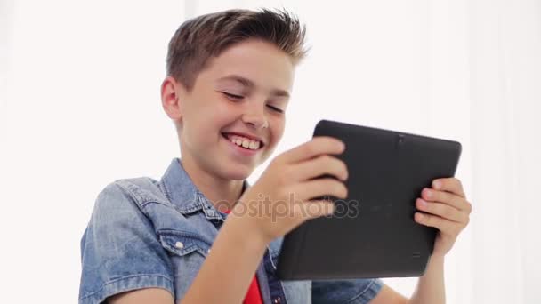 Χαμογελαστό αγόρι με υπολογιστή tablet pc στο σπίτι — Αρχείο Βίντεο