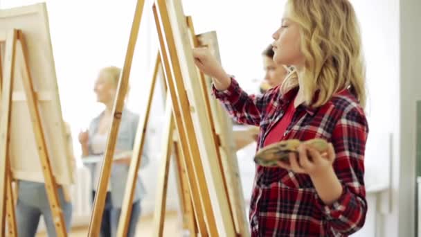 Students with easels painting at art school — Stock Video
