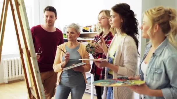 Grupo de artistas discutiendo pintura en la escuela de arte — Vídeos de Stock