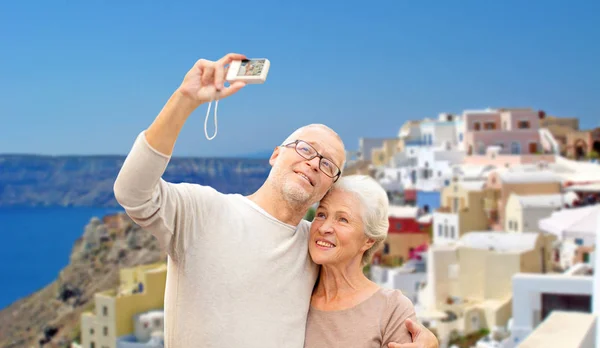 Senior couple with camera travelling in santorini — Stock Photo, Image