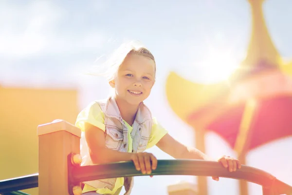 Fröhliches kleines Mädchen klettert auf Kinderspielplatz — Stockfoto