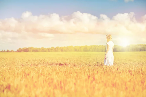 Happy young woman in flower wreath on cereal field — Stock Photo, Image