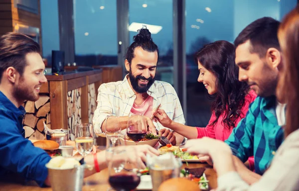 Amigos comer e degustação de alimentos no restaurante — Fotografia de Stock