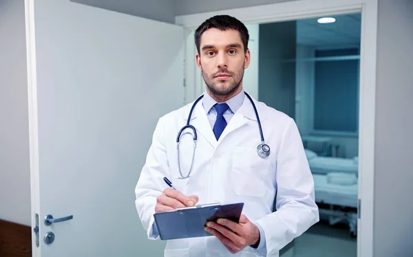 Doctor with stethoscope and clipboard at hospital — Stock Photo, Image