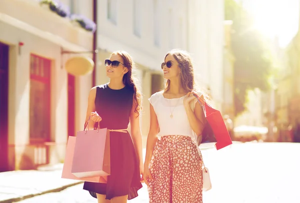 Gelukkig vrouwen met boodschappentassen wandelen in de stad — Stockfoto