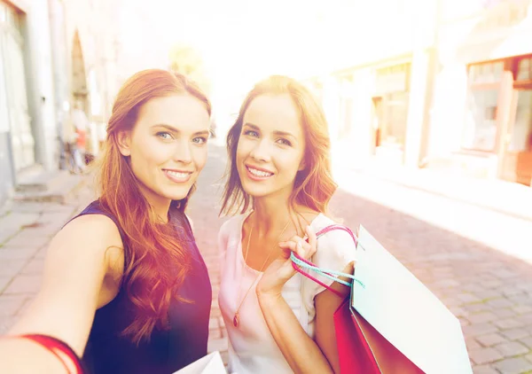 Mulheres fazendo compras e tirando selfie por smartphone — Fotografia de Stock